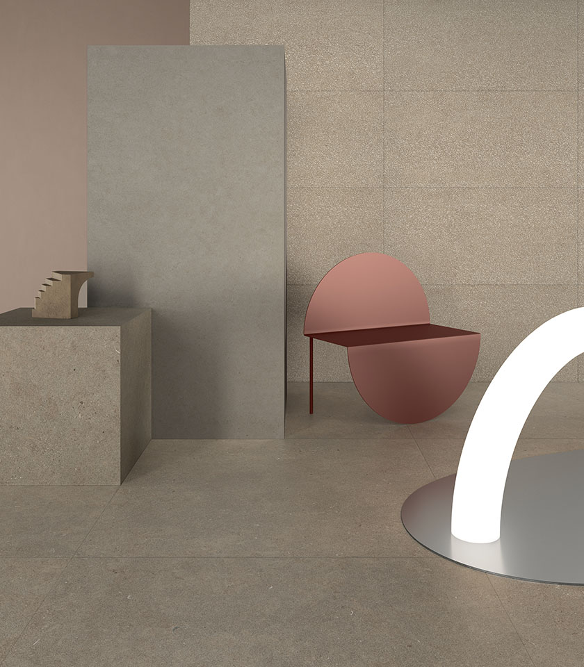 Ambiente minimalista con superfici effetto pietra, tonalità neutre e arredi scultorei per uno spazio contemporaneo ed essenziale.