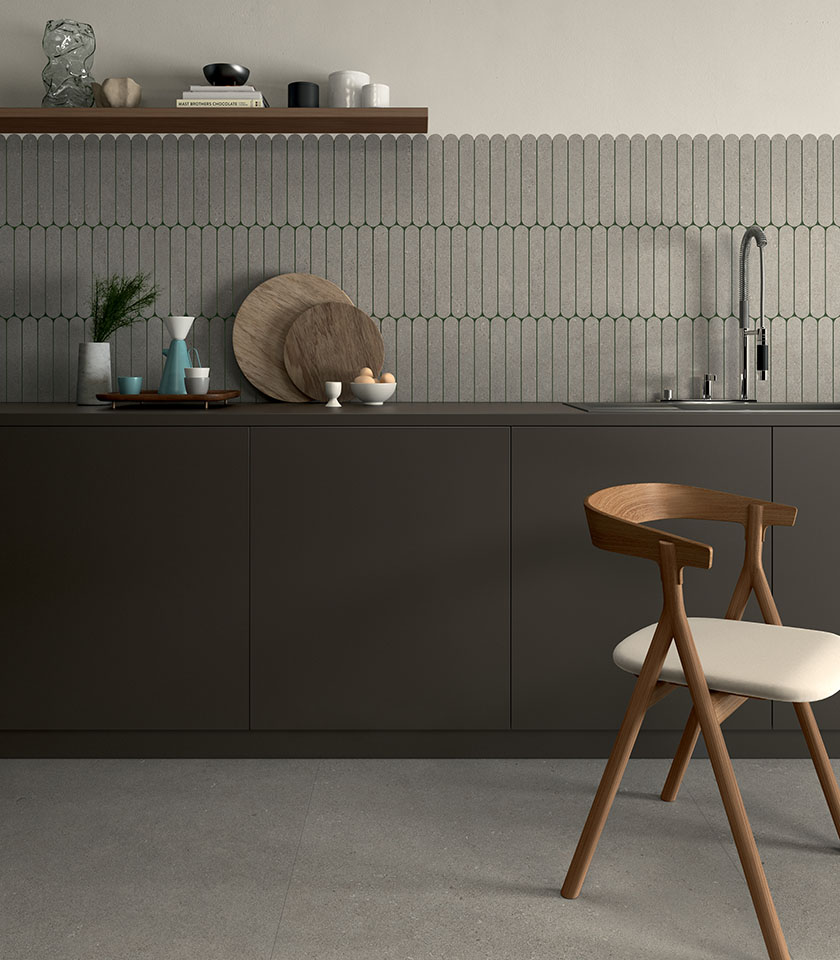 Cucina moderna con rivestimento geometrico, tonalità neutre e dettagli in legno.