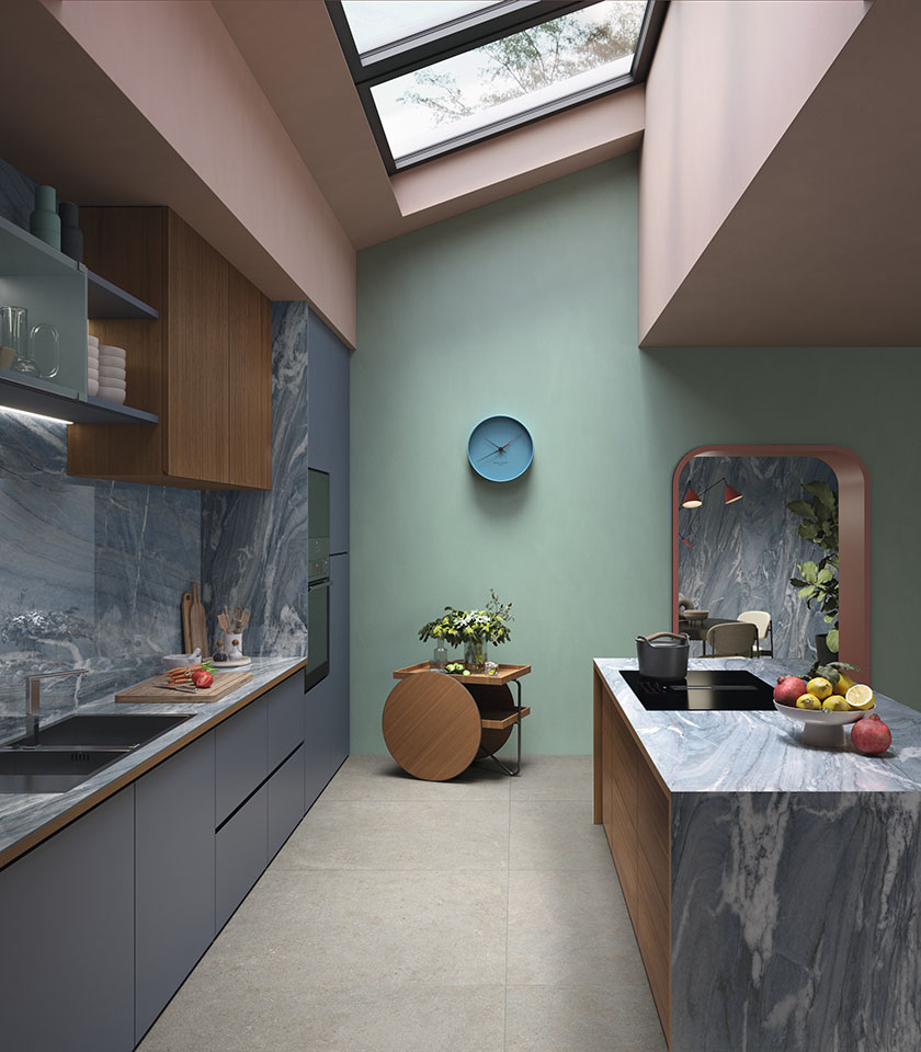 Cucina contemporanea con arredi in legno e superfici blu-grigie, pavimento della collezione Intense effetto pietra Crete e rivestimenti della collezione Noblesse effetto marmo Blue River.