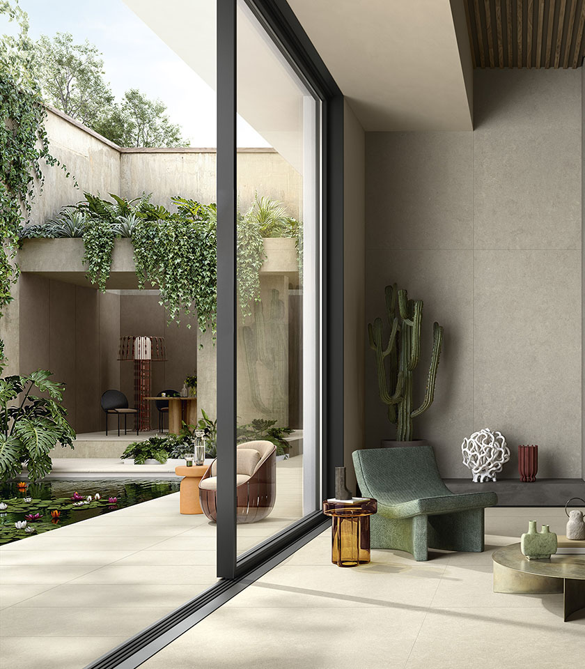 Ambiente indoor-outdoor contemporaneo con pavimento della collezione Intense effetto pietra nella tonalità Clair, rivestimento nella tonalità Perle ed elementi della collezione Pigmenti nella tonalità Pumice.
