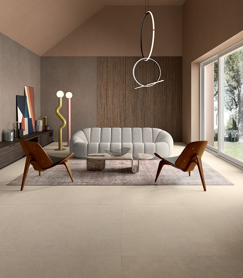 Living contemporaneo con pavimento della collezione Intense effetto pietra nella tonalità Beige e rivestimenti della collezione Pigmenti nella tonalità Pumice.