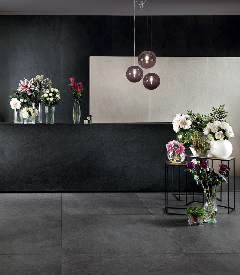 Spazio contemporaneo con pavimento e rivestimenti della collezione Waterfall effetto pietra nelle tonalità Gray Flow, Dark Flow e Ivory Flow.