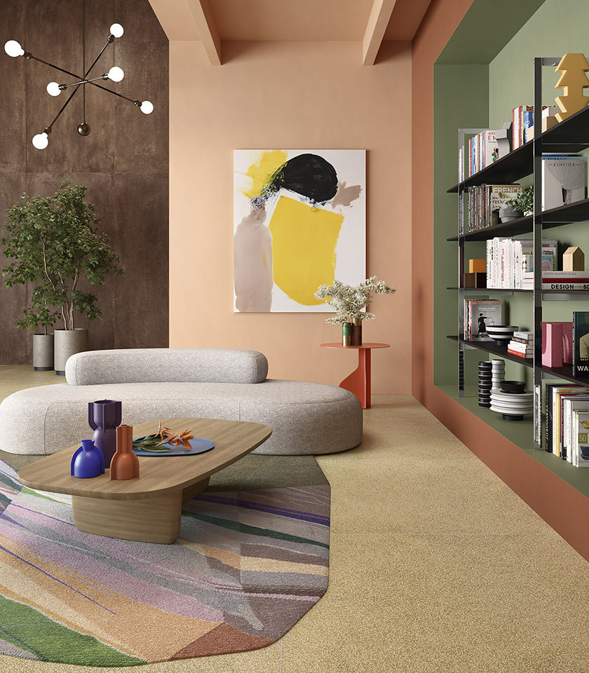 Soggiorno contemporaneo con pavimento beige, parete effetto cemento, divano scultoreo e libreria incassata su fondo verde.