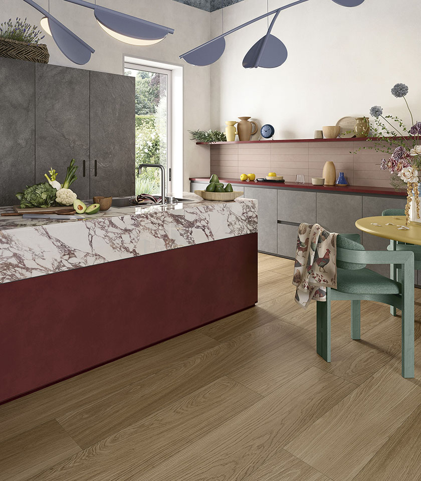 Cucina contemporanea con pavimento della collezione Biocharme effetto legno nella tonalità Bark, isola con superficie della collezione Noblesse effetto marmo Arabesque, elementi della collezione Pulse nella tonalità Shadow e rivestimento Pigmenti Mauve.