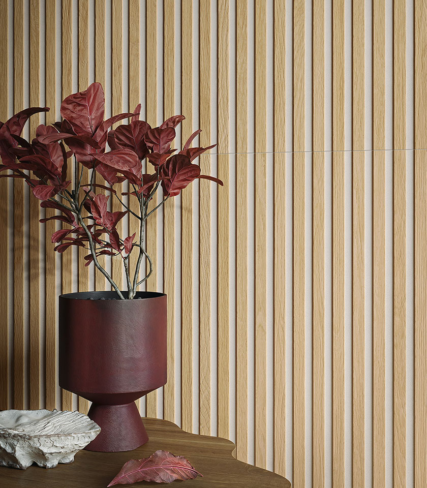 Dettaglio di rivestimento tridimensionale effetto legno chiaro con vaso bordeaux e composizione botanica decorativa.