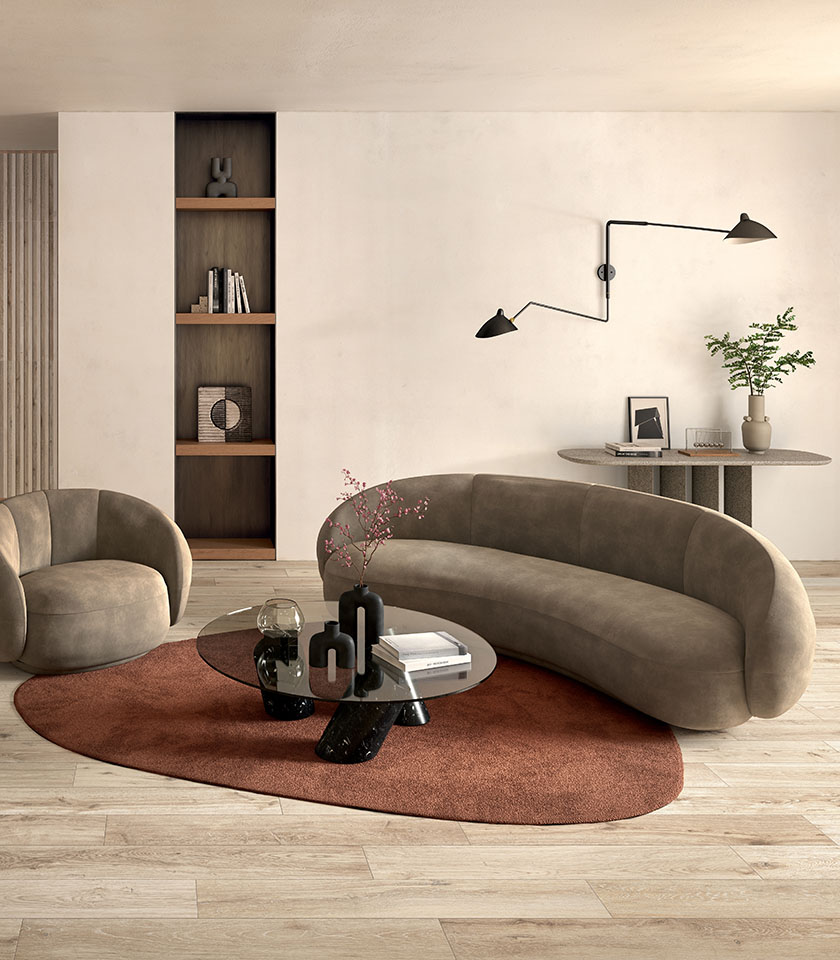 Living minimal chic con pavimento effetto legno chiaro, divano dalle linee morbide, arredi essenziali e dettagli caldi dal design contemporaneo.