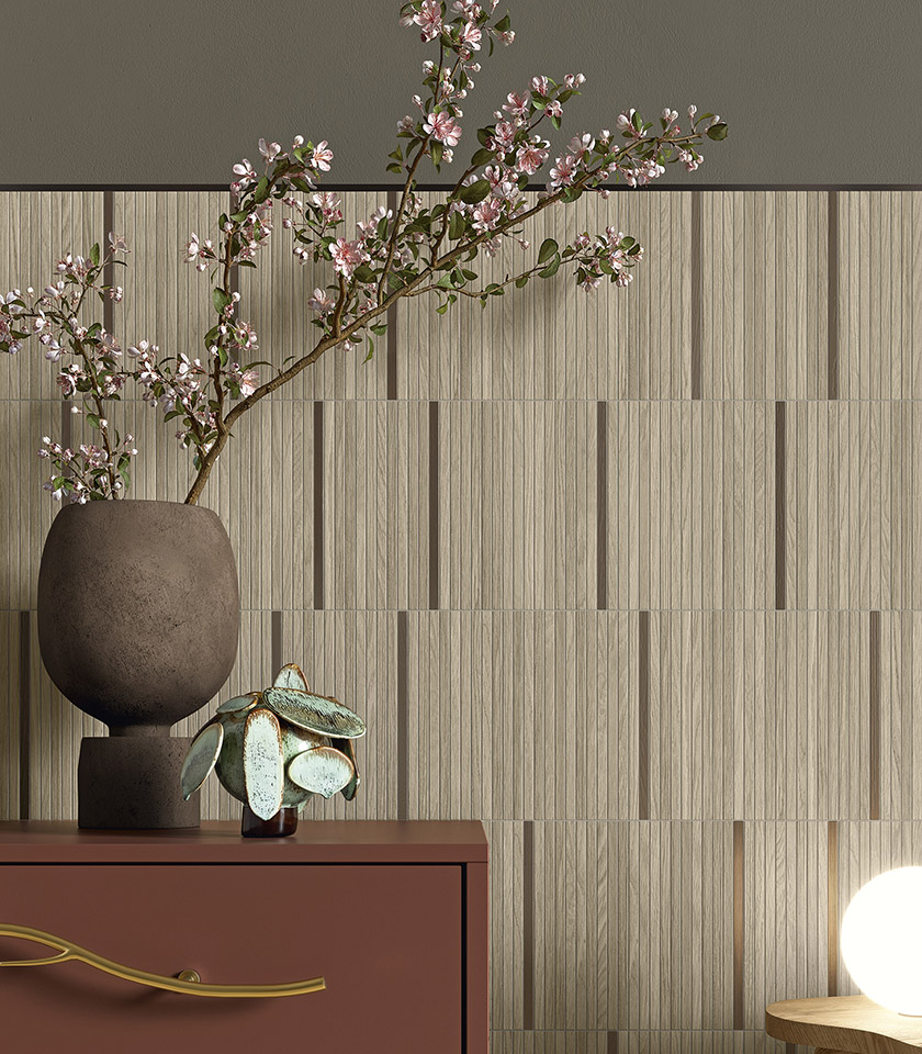 Interno in stile Japandi con rivestimento a parete effetto legno, vaso decorativo con rami fioriti e arredi dalle tonalità naturali.