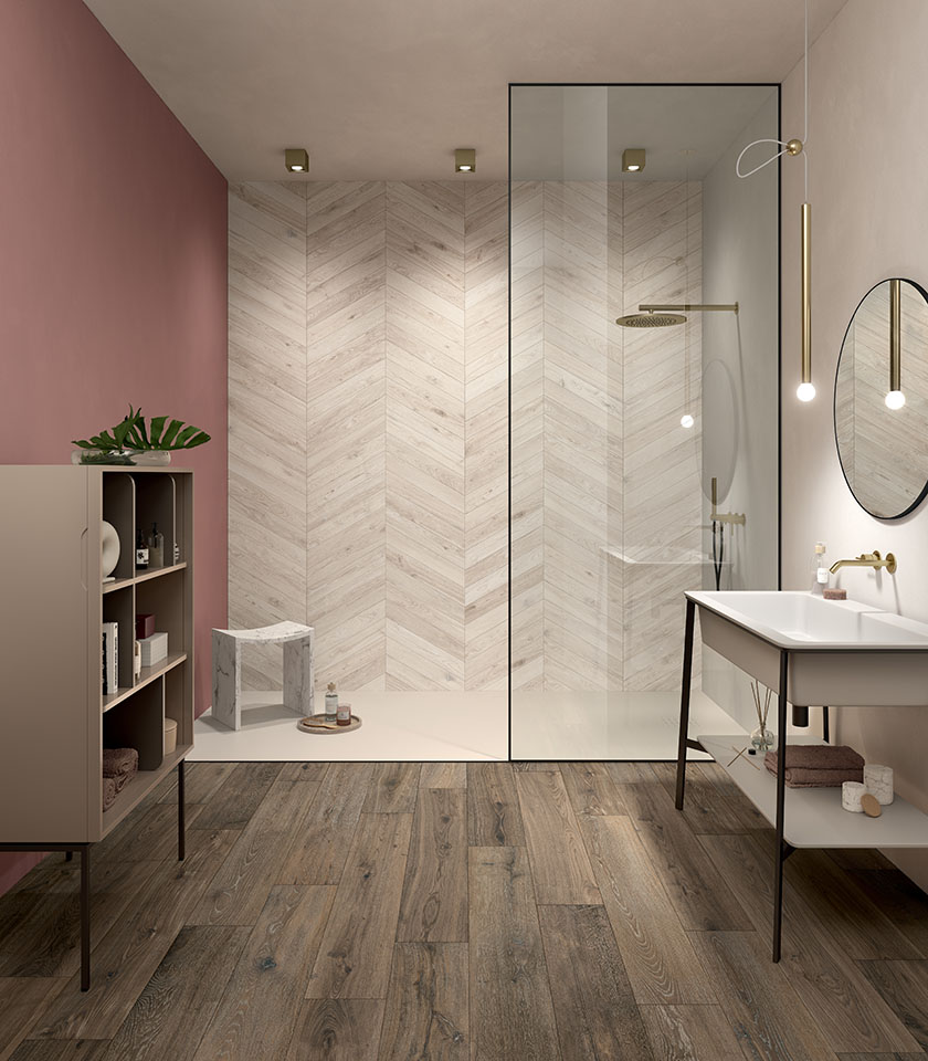 Bagno moderno con pavimento effetto legno e rivestimento a spina di pesce, tonalità calde e dettagli eleganti per un ambiente accogliente e contemporaneo.